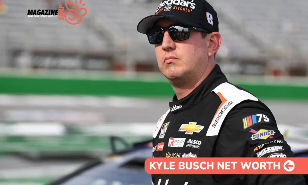 Kyle Busch net worth photo, driver in Cheddar's Scratch Kitchen racing suit standing trackside