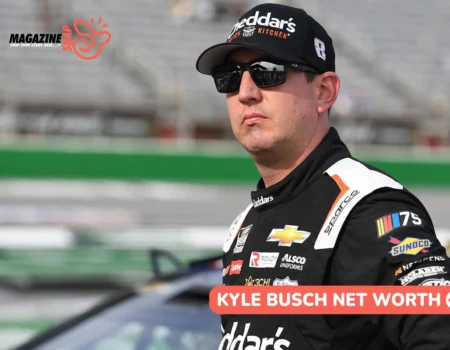 Kyle Busch net worth photo, driver in Cheddar's Scratch Kitchen racing suit standing trackside