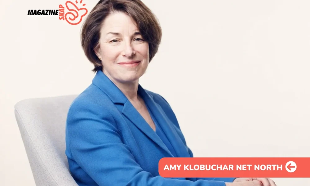 Amy Klobuchar smiling in blue blazer, seated in gray armchair for portrait