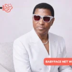 Babyface Net Worth: man in white suit and tinted sunglasses seated on gray chair