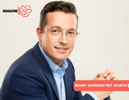 Benny Johnson net worth profile photo: seated headshot in navy blazer