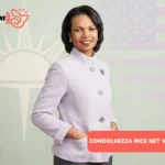 Condoleezza Rice smiling in lavender blazer with pearl earrings and brooch pin