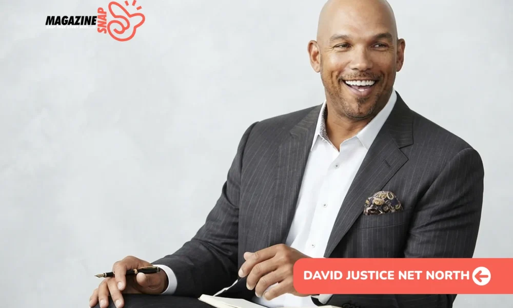 David Justice net worth portrait, smiling in gray pinstripe suit holding pen over notebook