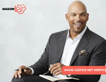 David Justice net worth portrait, smiling in gray pinstripe suit holding pen over notebook
