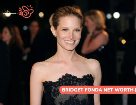 Bridget Fonda net worth article: she smiles in a black strapless lace dress at a night event