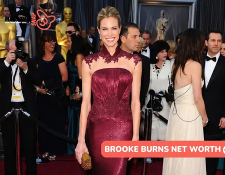 Brooke Burns in a burgundy lace-trim gown on a red carpet for the Brooke Burns net worth article.