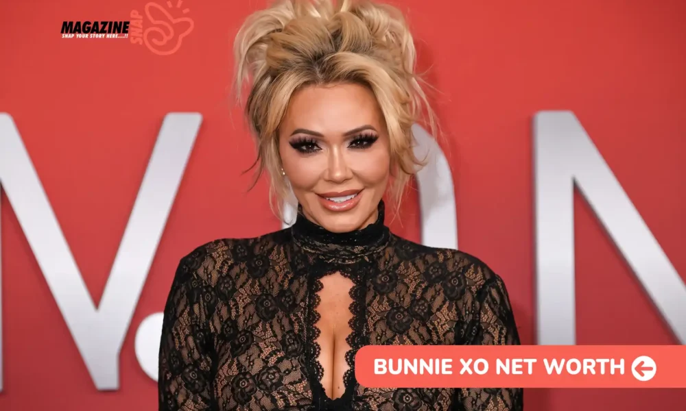 Bunnie Xo Net Worth 2026 – $10M Estimate and Dumb Blonde Podcast Blonde-haired Bunnie Xo smiling in a black lace top against a red backdrop, for Bunnie Xo net worth article