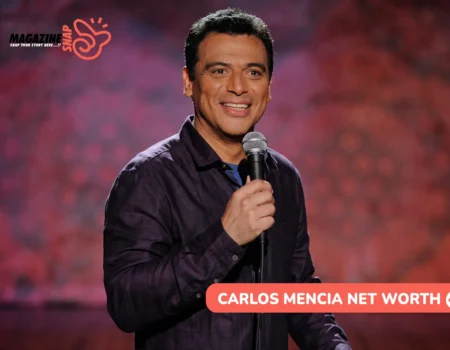 Carlos Mencia smiling on stage with a microphone in a purple shirt, Carlos Mencia net worth article photo
