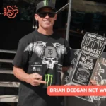 Deegan in a Monster Energy cap and sunglasses holding a 2nd Stock trophy for the Brian Deegan net worth article