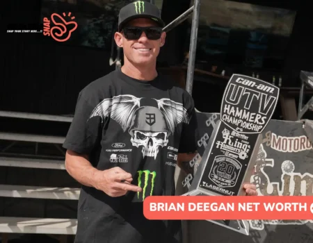 Deegan in a Monster Energy cap and sunglasses holding a 2nd Stock trophy for the Brian Deegan net worth article