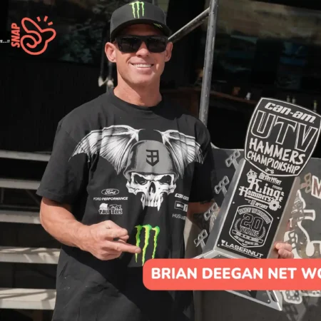 Deegan in a Monster Energy cap and sunglasses holding a 2nd Stock trophy for the Brian Deegan net worth article