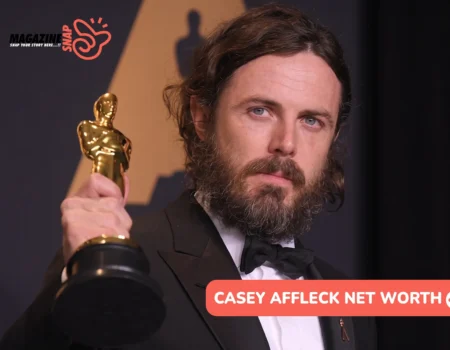 Casey Affleck net worth article: bearded actor in a black tuxedo holding a gold Oscar statuette