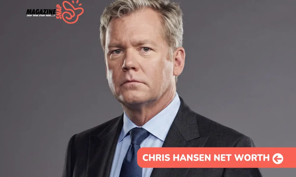 Chris Hansen net worth article portrait: man in a charcoal suit and navy tie on a gray studio backdrop