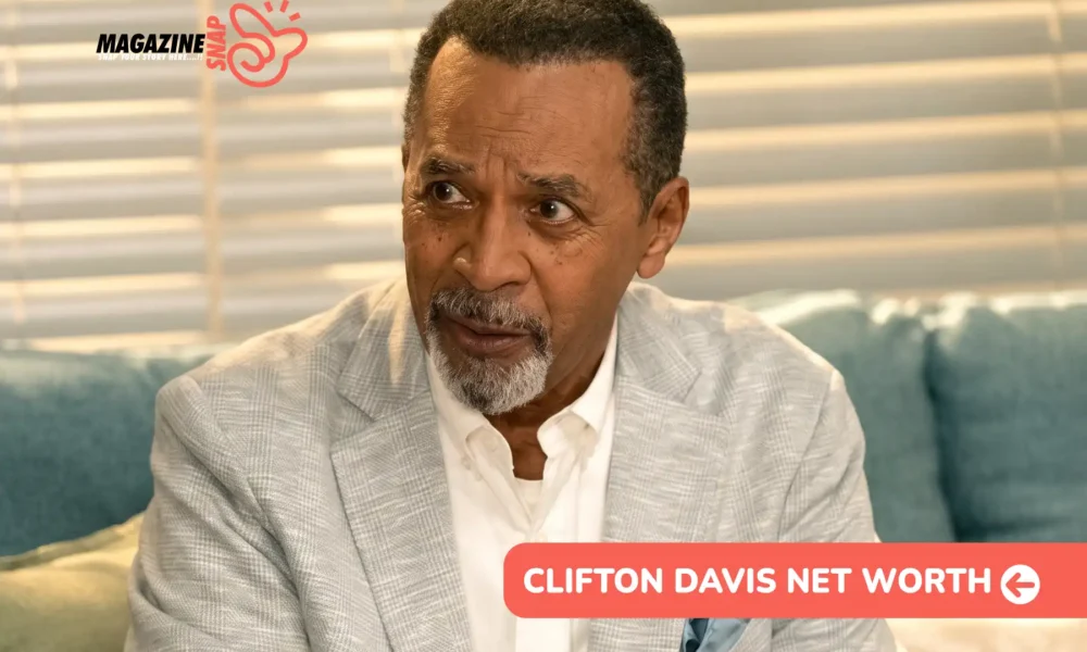 Clifton Davis in a light gray blazer and white shirt on a teal sofa, for the Clifton Davis net worth article