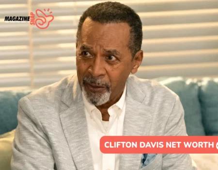 Clifton Davis in a light gray blazer and white shirt on a teal sofa, for the Clifton Davis net worth article